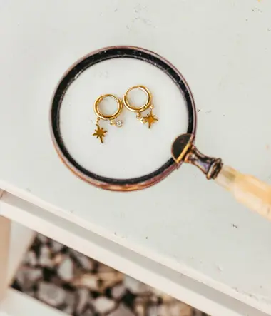 boucles-doreilles-cap-skirring-acier-dore-nature-morte_380x443_crop_center.webp